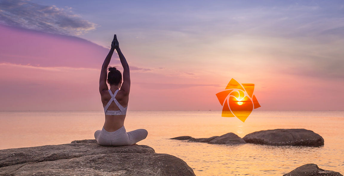 Mujer haciendo yoga fente al mar